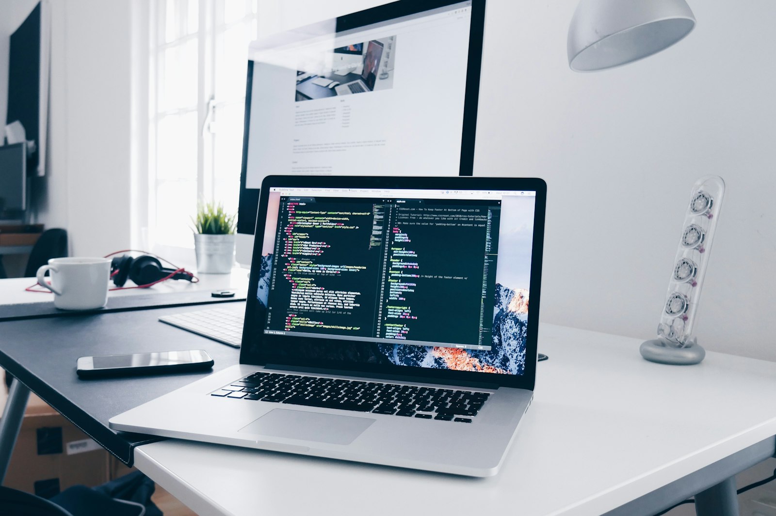 Clean modern workspace with laptop and code